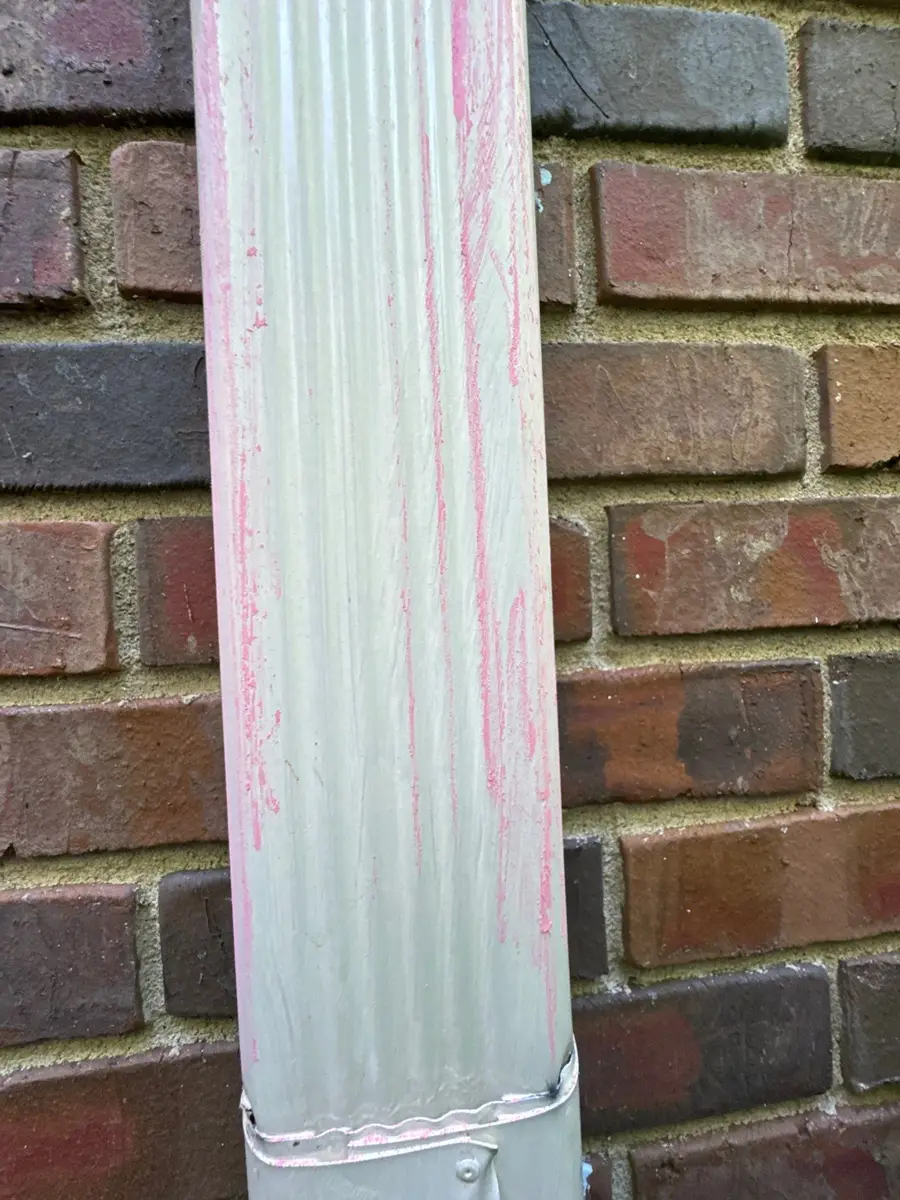 White downspout attached against brick wall with roof trim, Southern Premier Roofing work near Bostwick GA