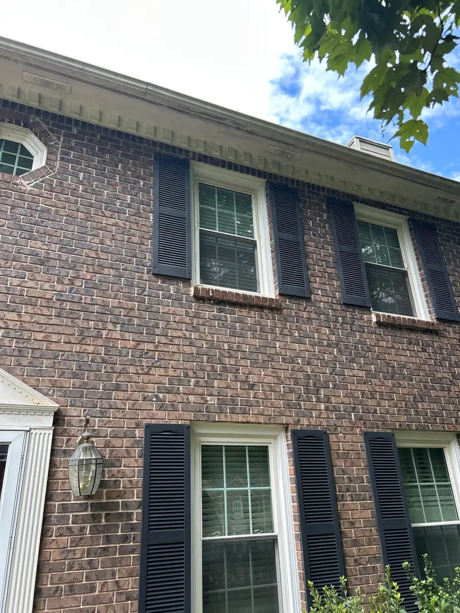 Brick home exterior showing roofline, gutters, windows, and shutters, Southern Premier Roofing work near Carl GA