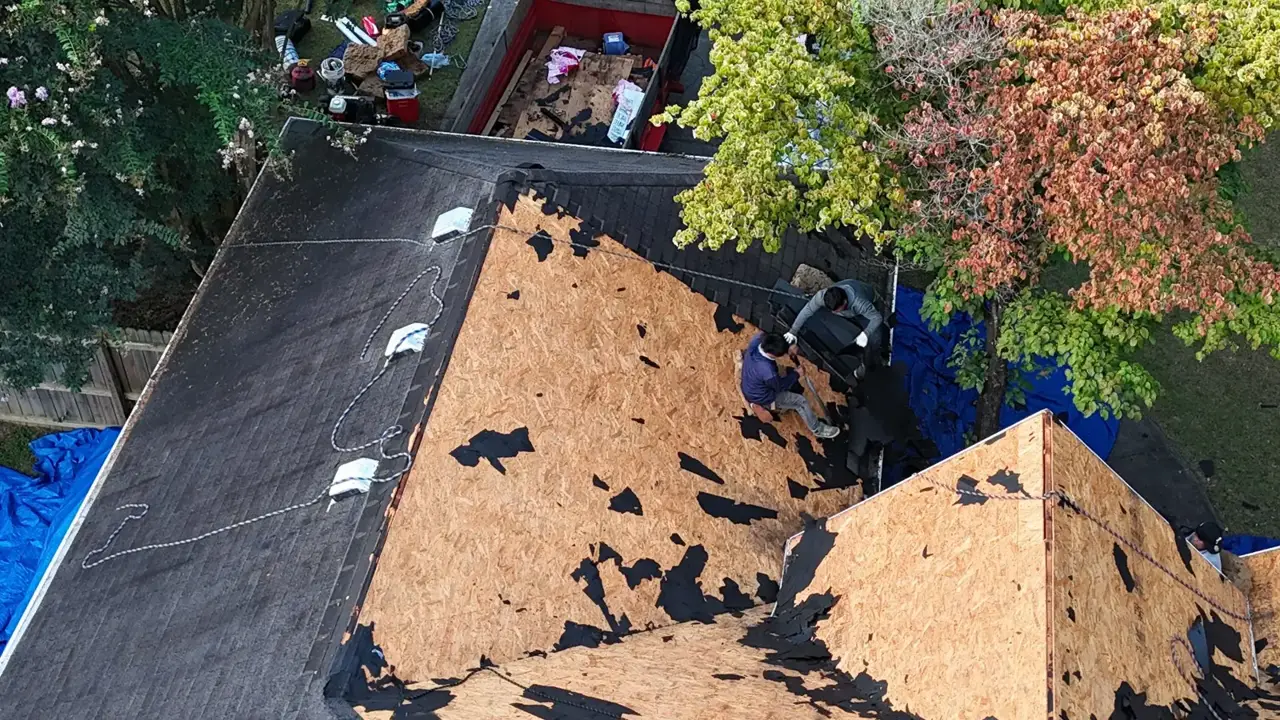 Roof replacement in Bethlehem, Georgia shows exposed sheathing, remaining underlayment, and workers on the roof.