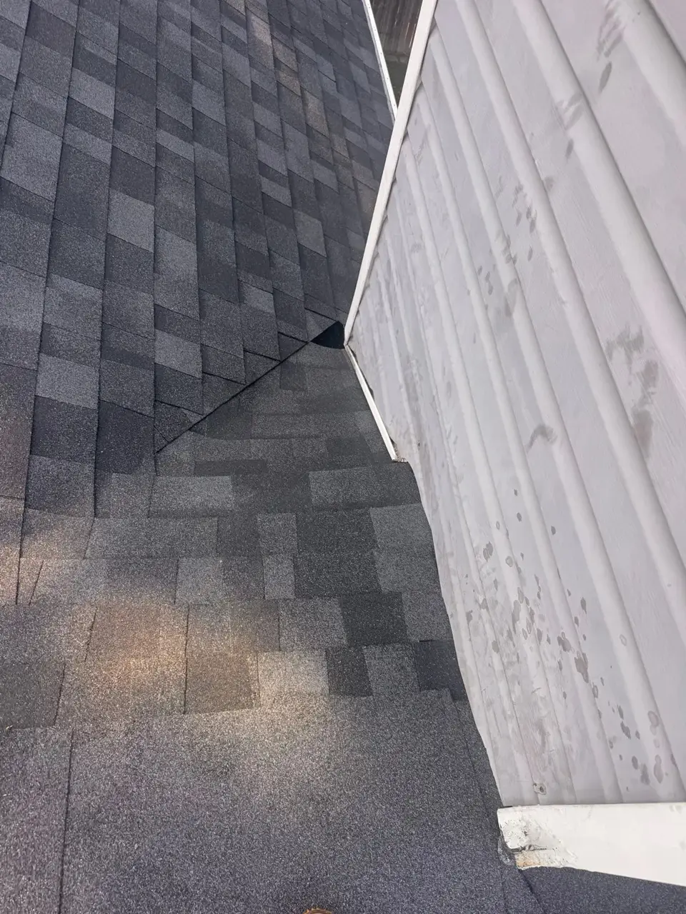 Gray shingles meet white vertical siding at a narrow roof intersection, with Bethlehem, Georgia visible.