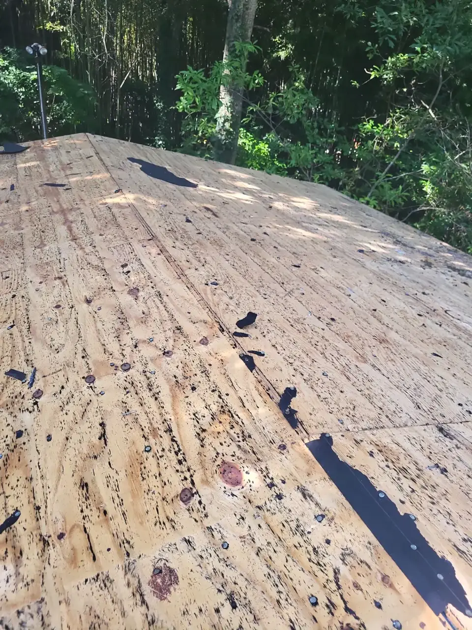 Exposed roof decking with dark patches and scattered debris in Conyers GA