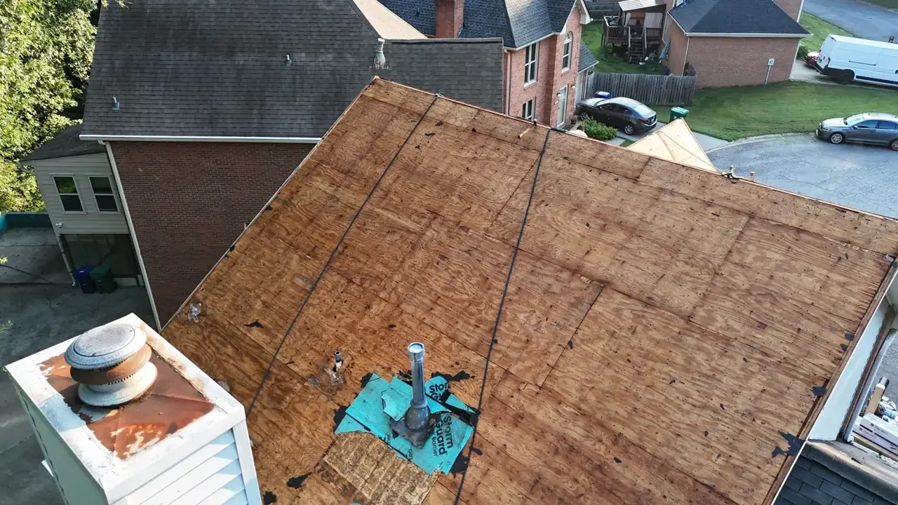 Close aerial view of exposed roof decking, vents, chimney, and surrounding homes in Decatur GA