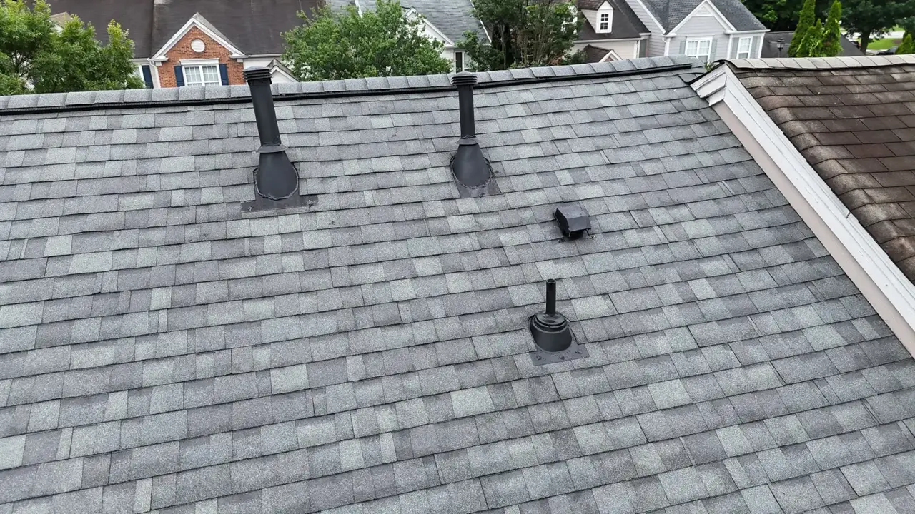 Completed gray shingle roof with multiple vent pipes overlooking neighboring homes in Duluth, Georgia