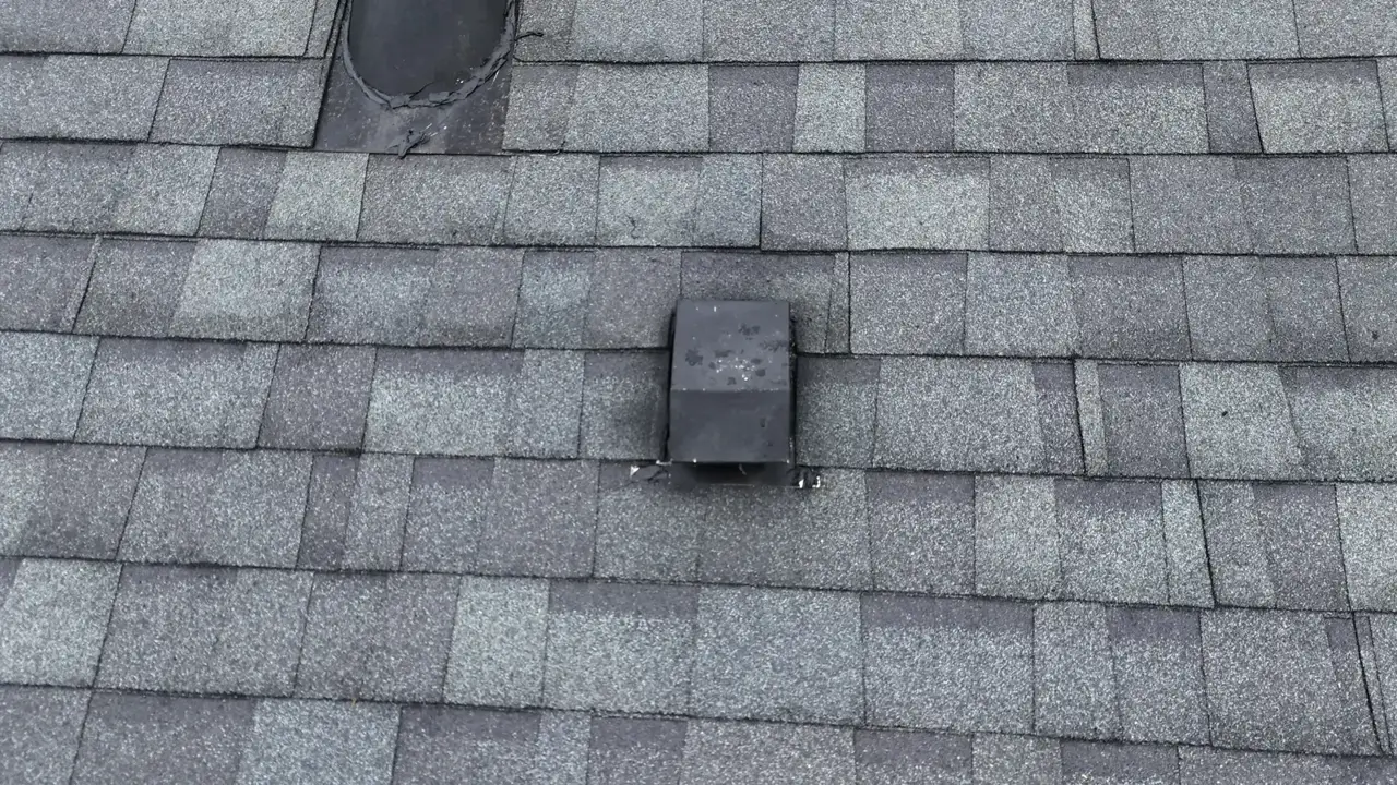 Close view of gray asphalt shingles and roof vent on a residential roof in Duluth, GA