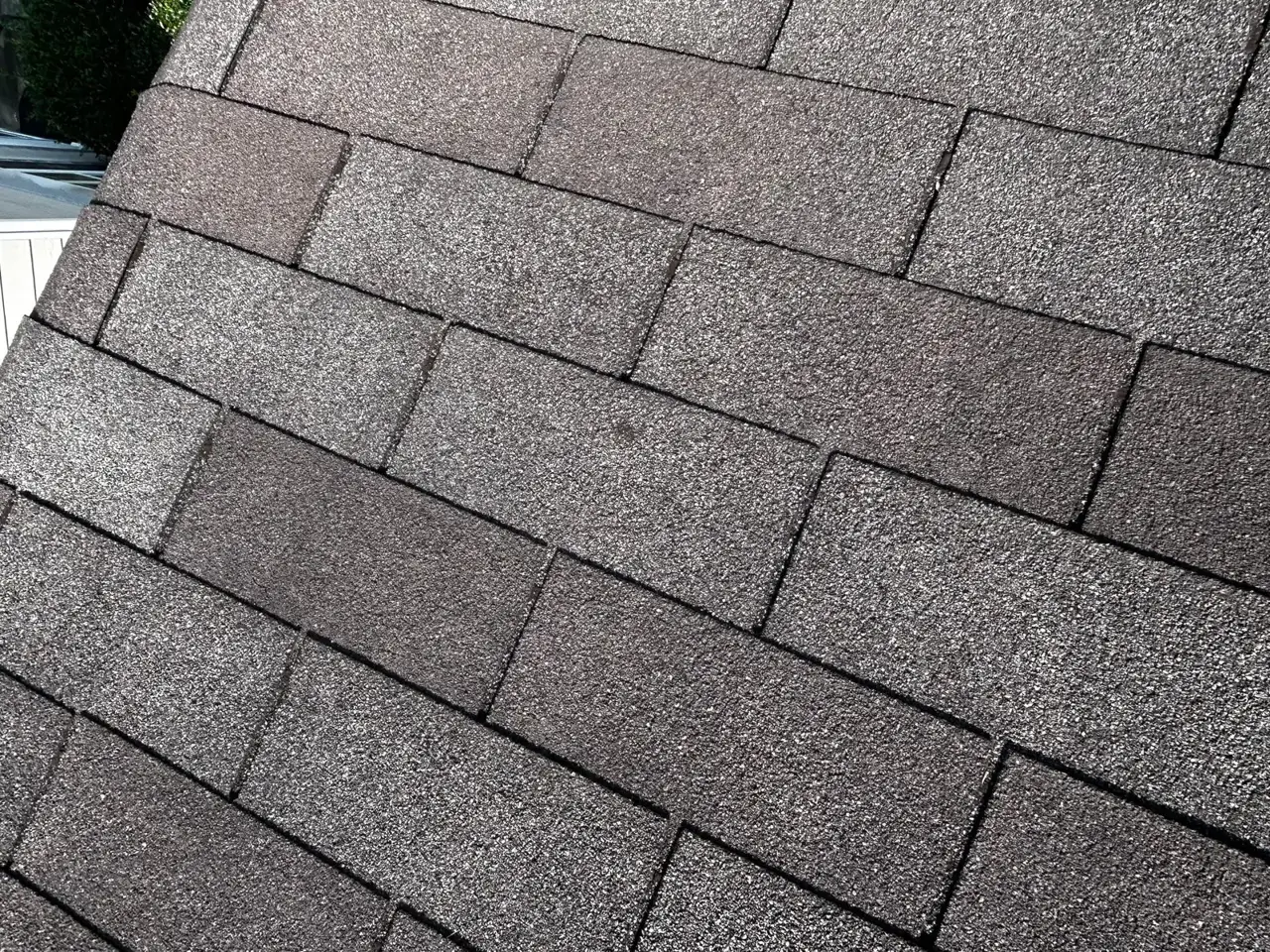 Close-up view of overlapping gray asphalt shingles covering a residential roof.