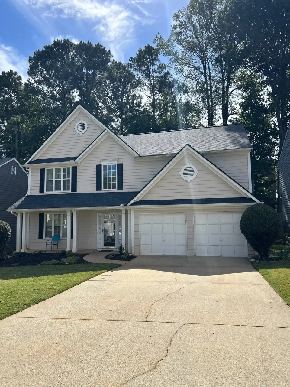 Completed residential roof replacement viewed from the driveway, with attached garage and dark shingles in Kennesaw GA.