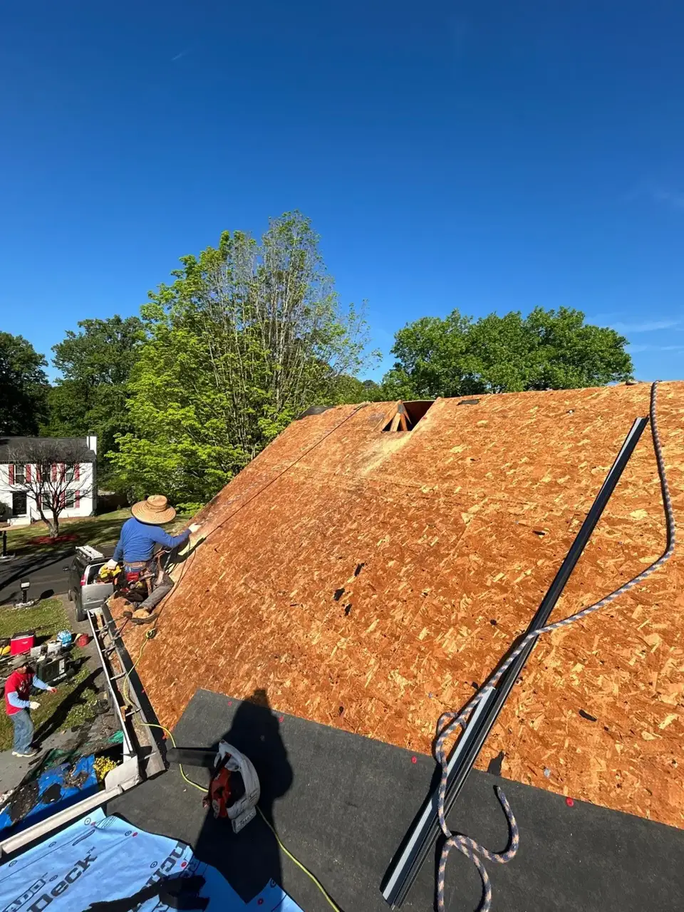 Roof decking and underlayment surround workers on a residential home in Lawrenceville GA