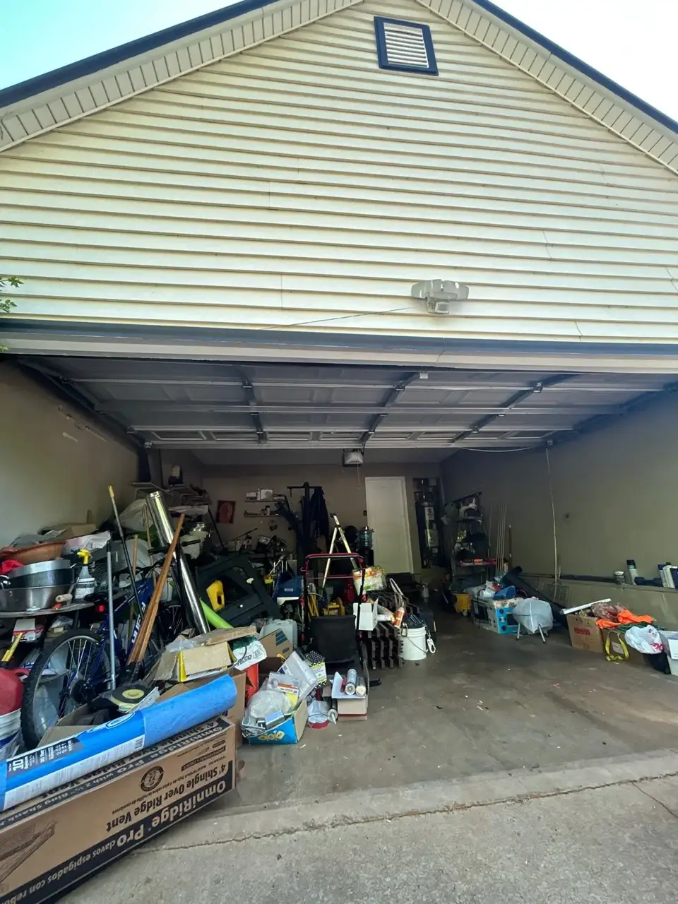 Open garage beneath residential siding and gable roof in Lawrenceville, Georgia.