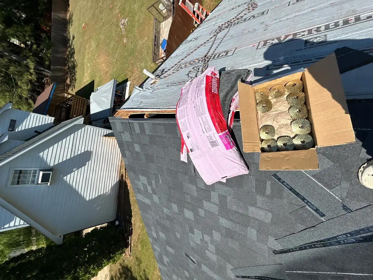 Roof replacement materials and shingle bundles on a covered roof in Lawrenceville, GA