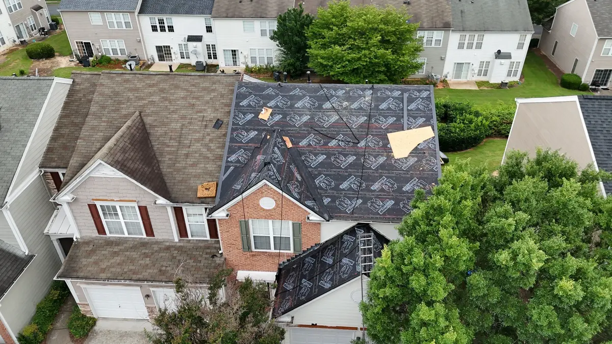 Aerial view shows partially removed roofing across residential house, Southern Premier Roofing work near Berkeley Lake GA