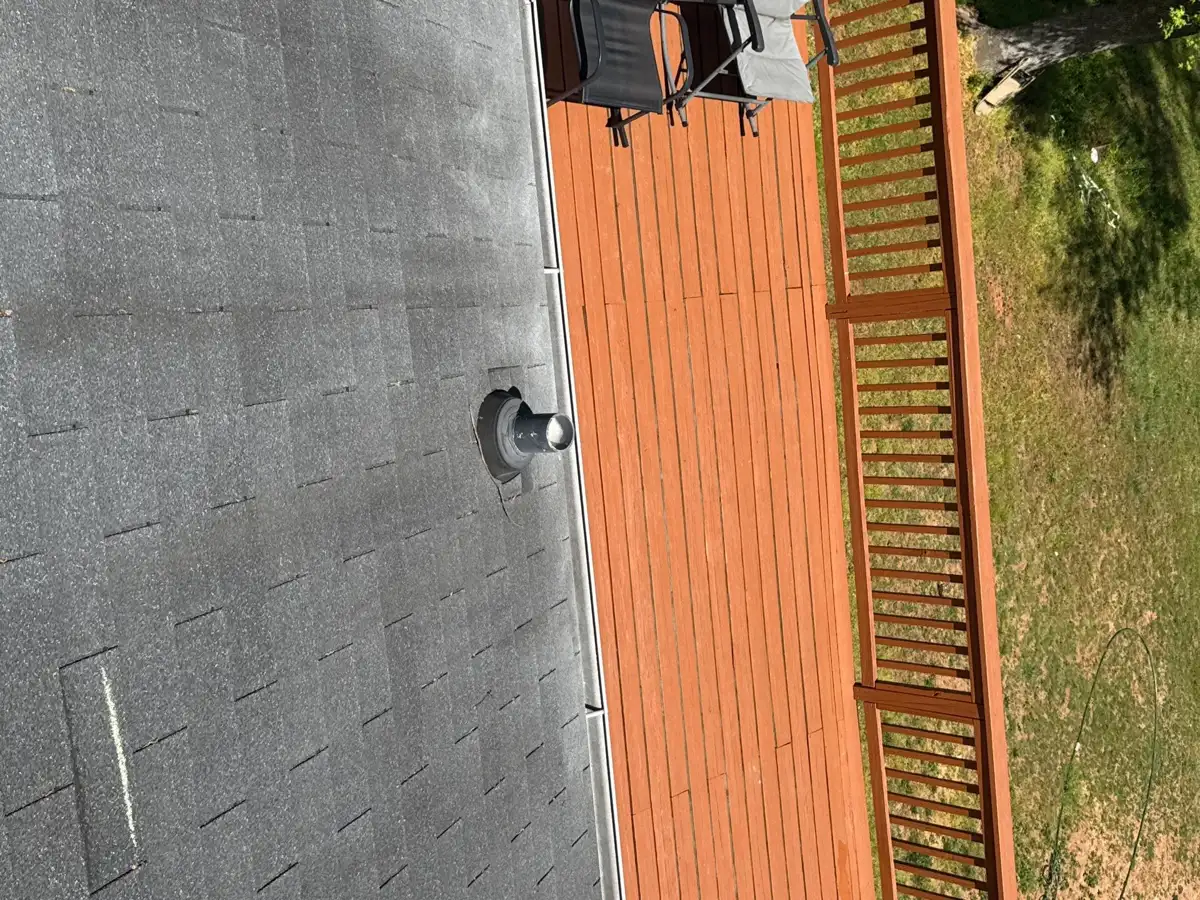 Roof edge flashing beside orange roof and wooden railing, Southern Premier Roofing work near Berkeley Lake GA