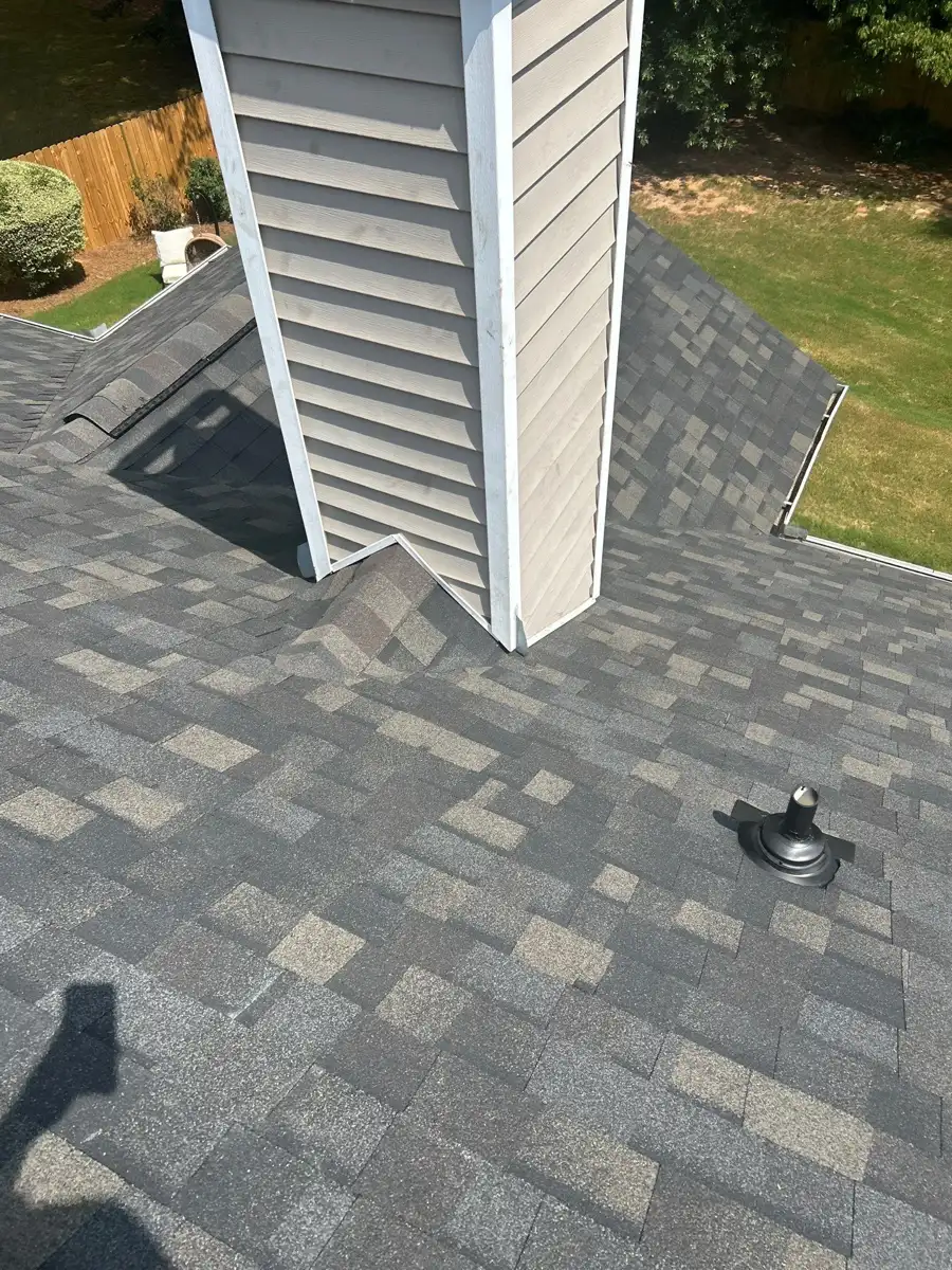 Completed shingles around tall wall penetration and roof vent, Southern Premier Roofing work near Between GA