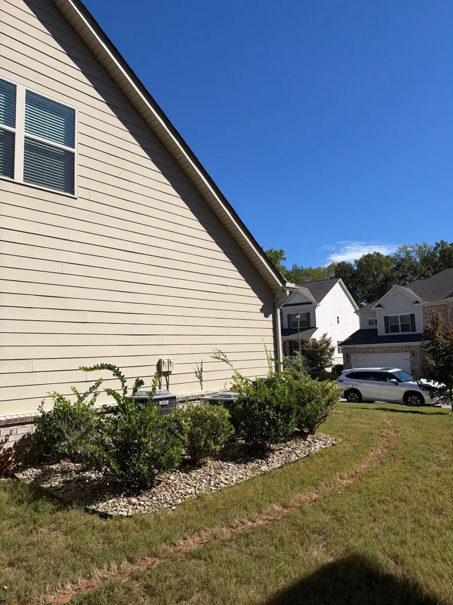 Side house elevation with roof edge, landscaping, and neighboring homes, Southern Premier Roofing work near Buford GA