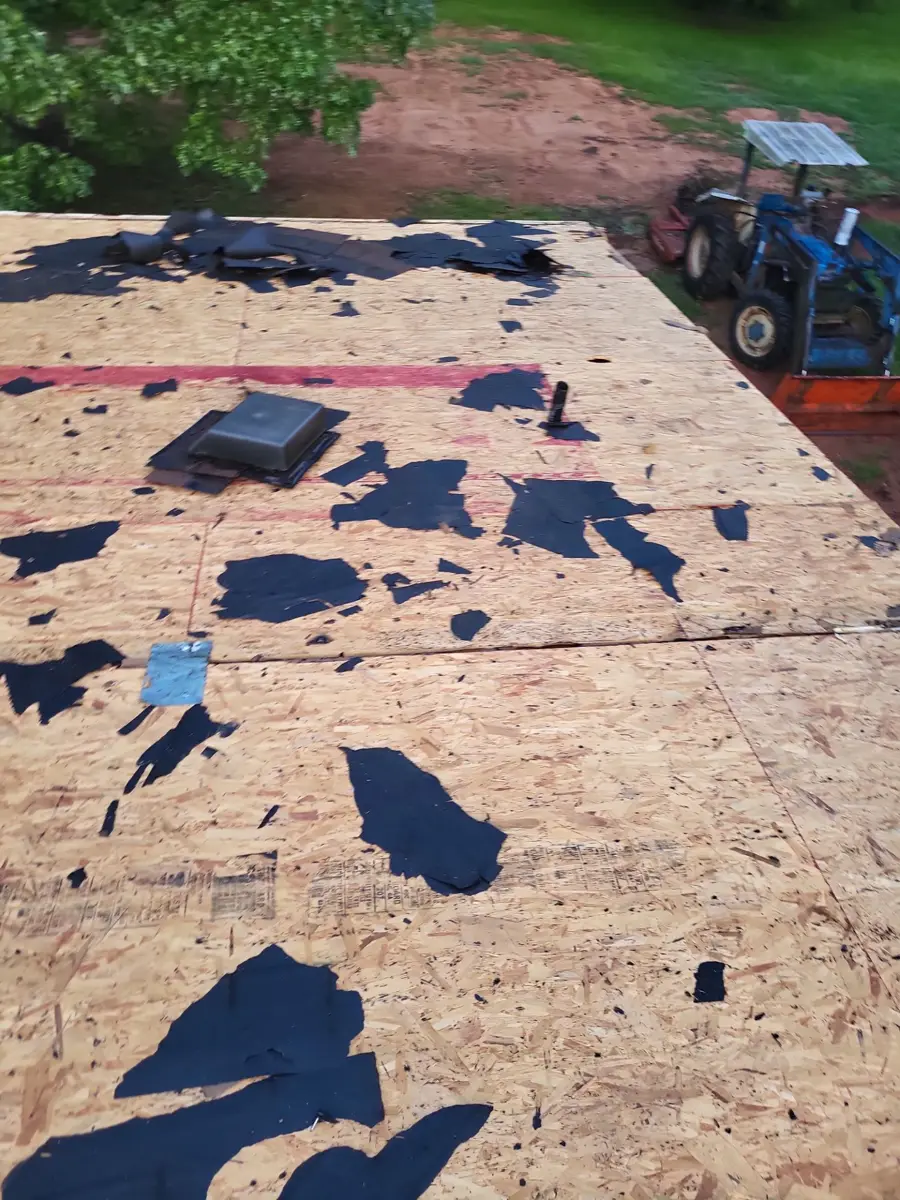 Roof stripped to plywood decking with scattered removed shingles, Southern Premier Roofing work near Colbert GA