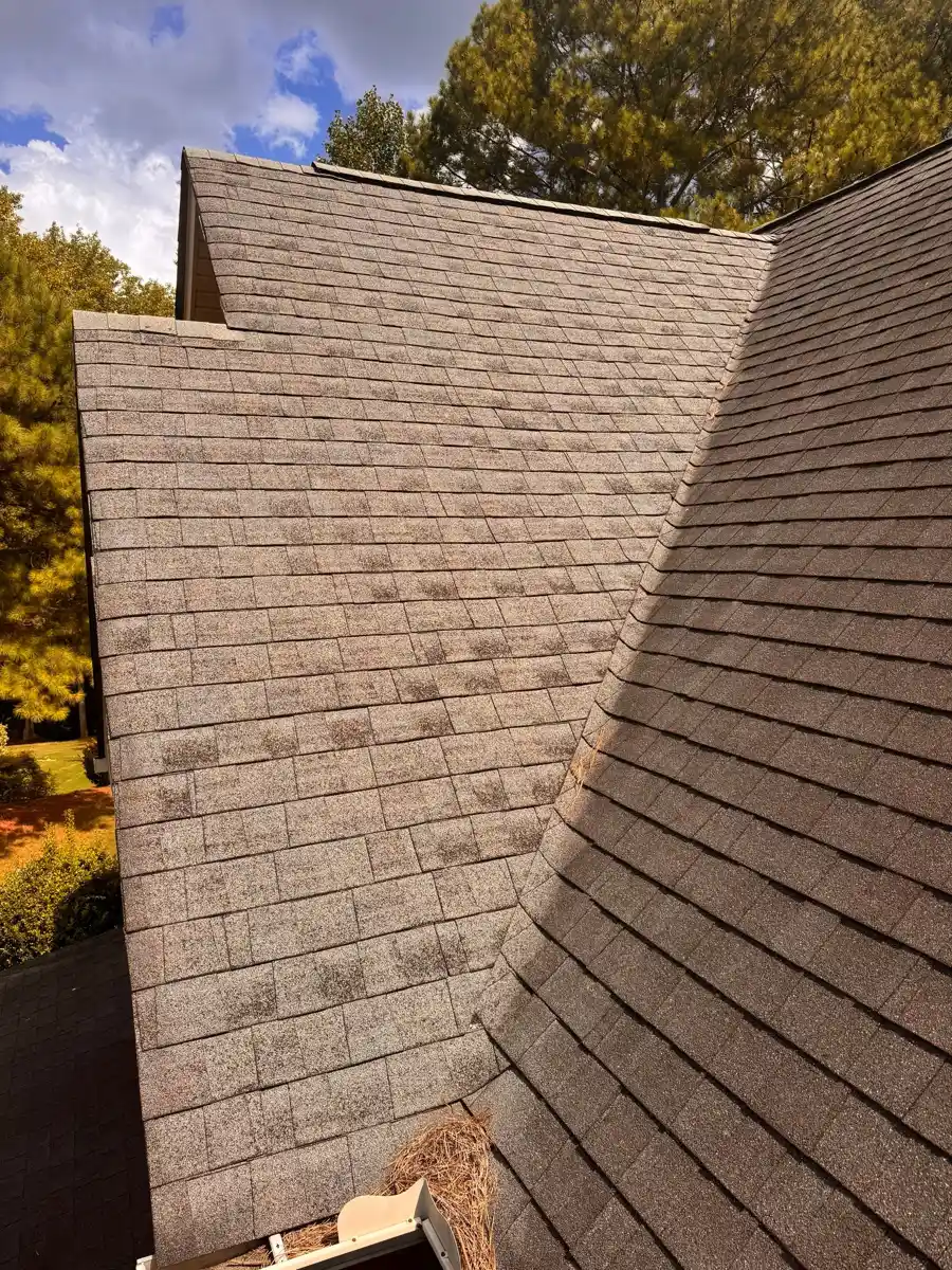 Wide view shows overlapping shingle roof sections beneath trees, Southern Premier Roofing work near Conyers GA