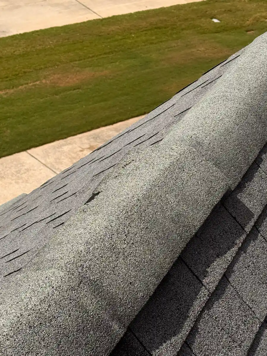 Ridge cap runs along shingle roof above driveway, Southern Premier Roofing work near Dacula GA