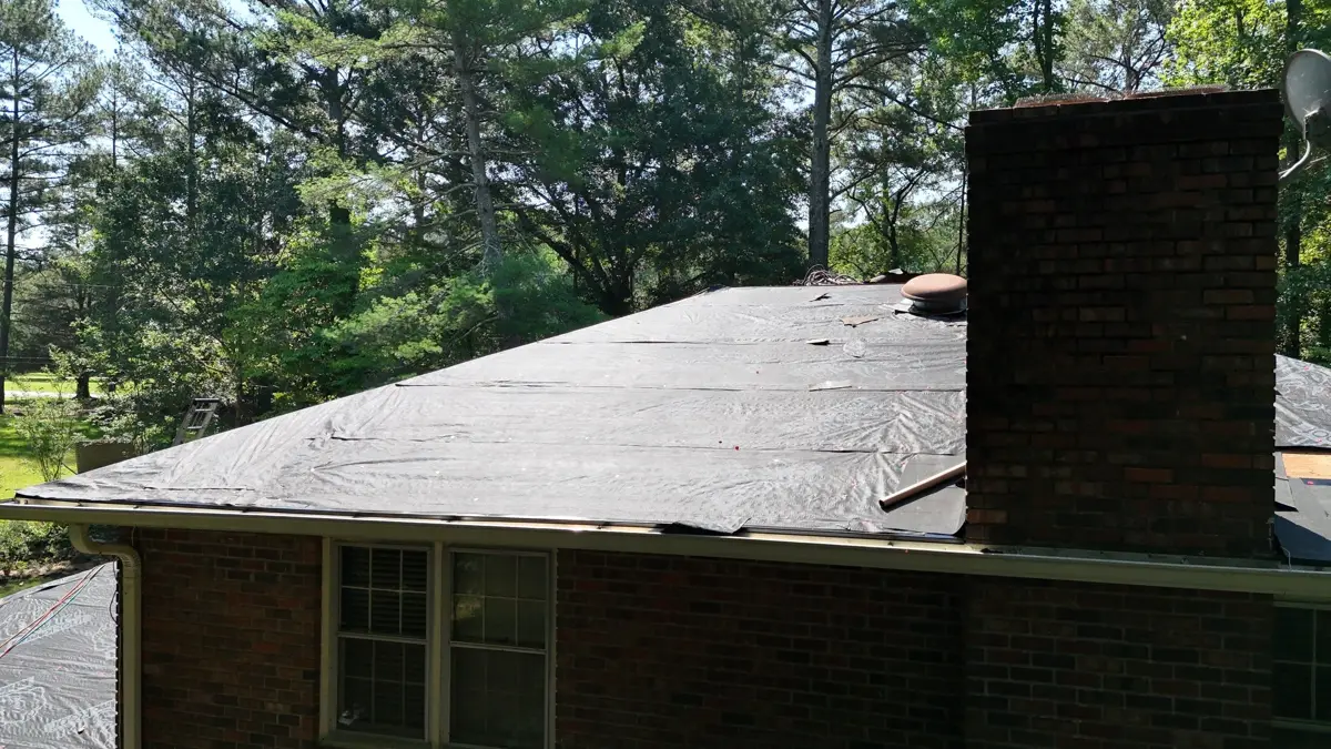 Completed dark roof with chimney above brick residential home, Southern Premier Roofing work near Flowery Branch GA