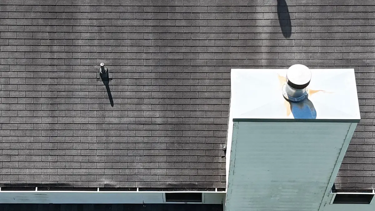 Close aerial view of dark shingles, vents, and chimney, Southern Premier Roofing work near Hull GA