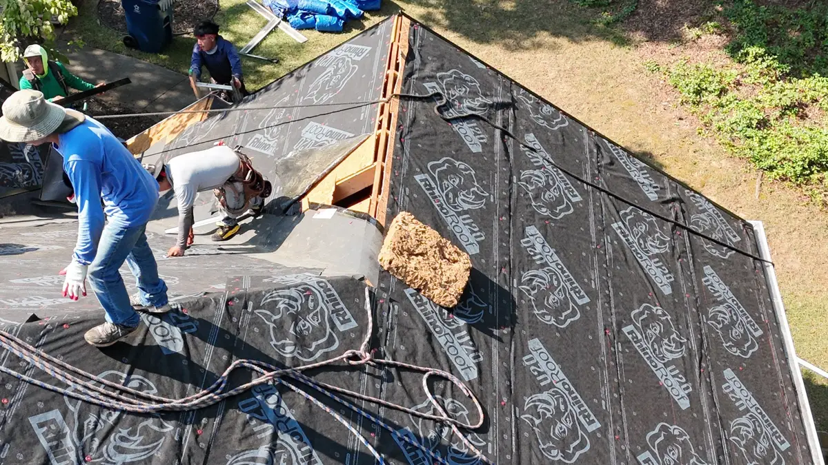 Workers installing black roofing underlayment across exposed roof deck, Southern Premier Roofing work near Hull GA