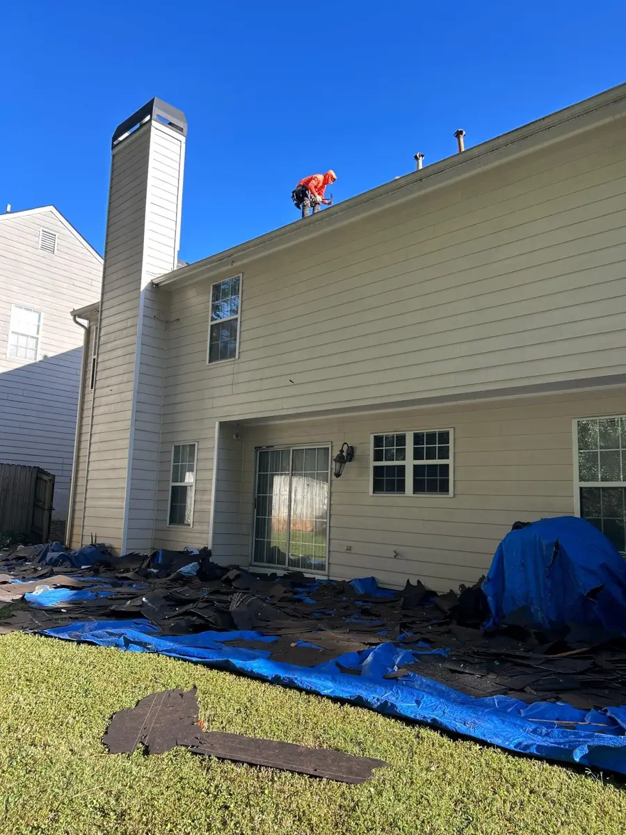 Roofing crew works beside house with removed shingles below, Southern Premier Roofing work near Jefferson GA