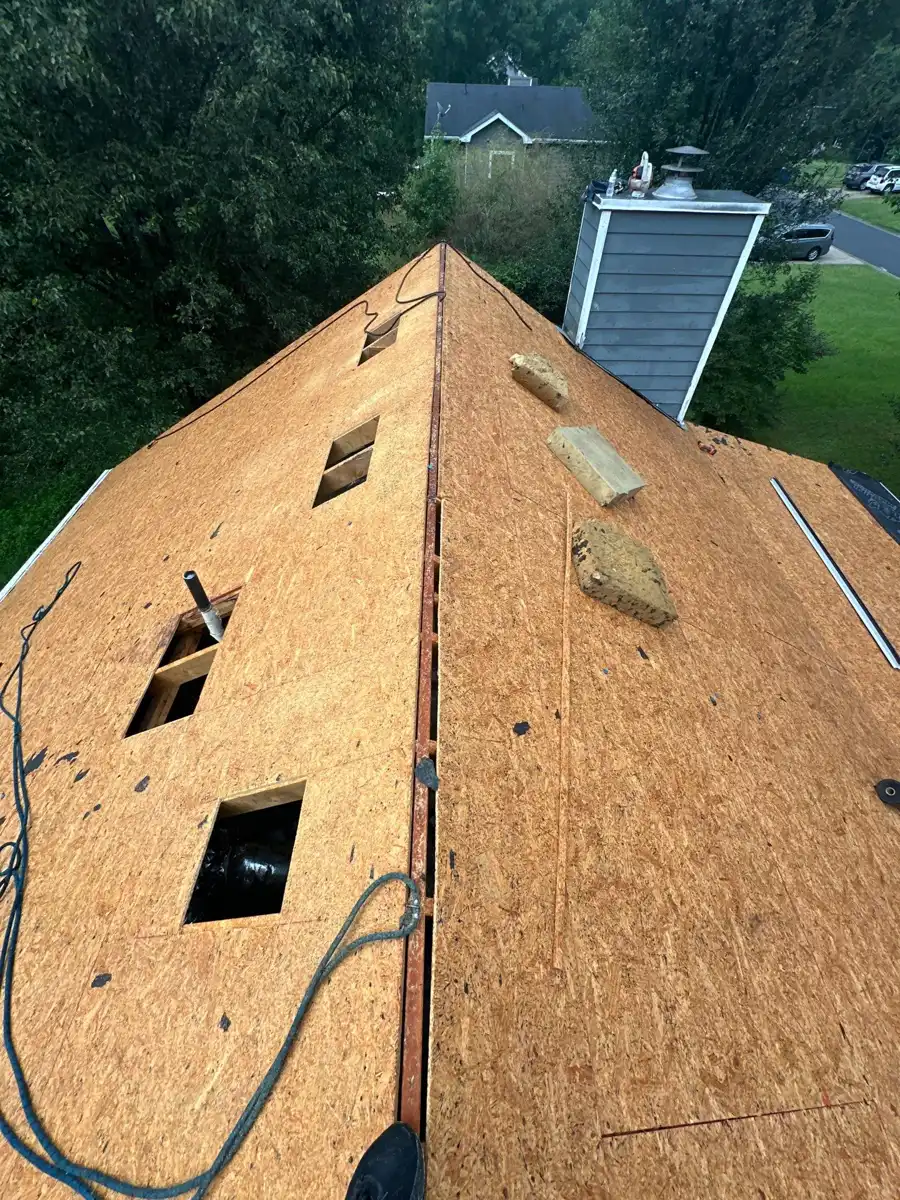 Exposed roof decking has multiple openings and scattered roofing debris, Southern Premier Roofing work near Lithonia GA