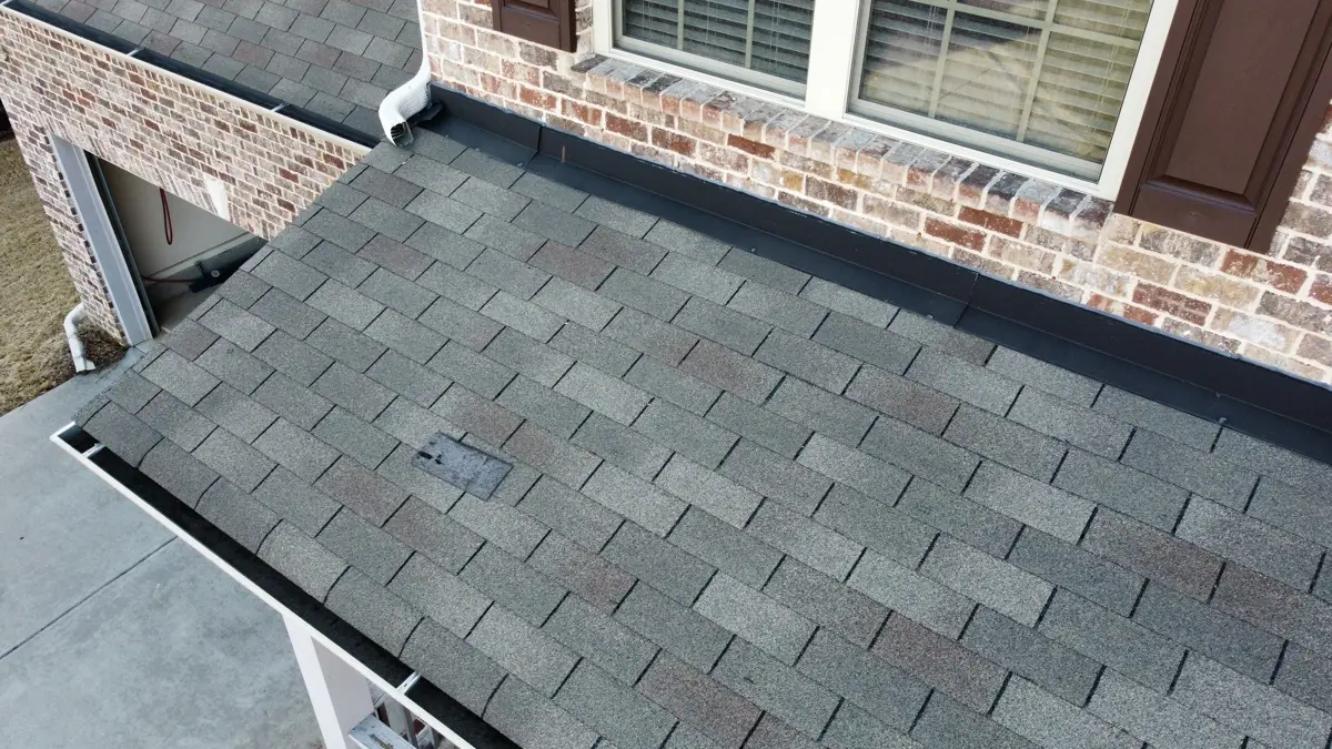 Completed gray shingle roof section beside brick house walls, Southern Premier Roofing work near Loganville GA