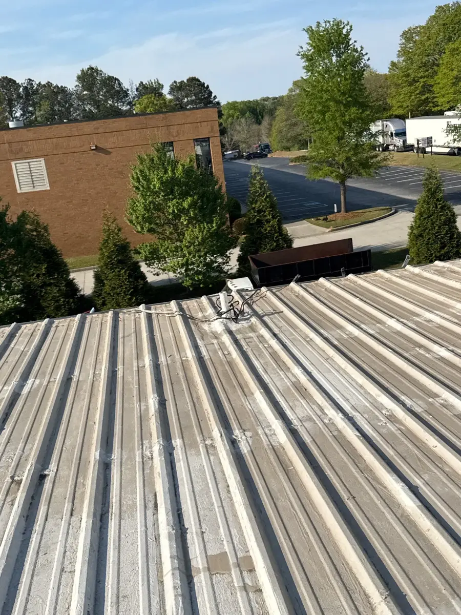 Wide view of clean ribbed metal roof overlooking nearby buildings, Southern Premier Roofing work near Lula GA