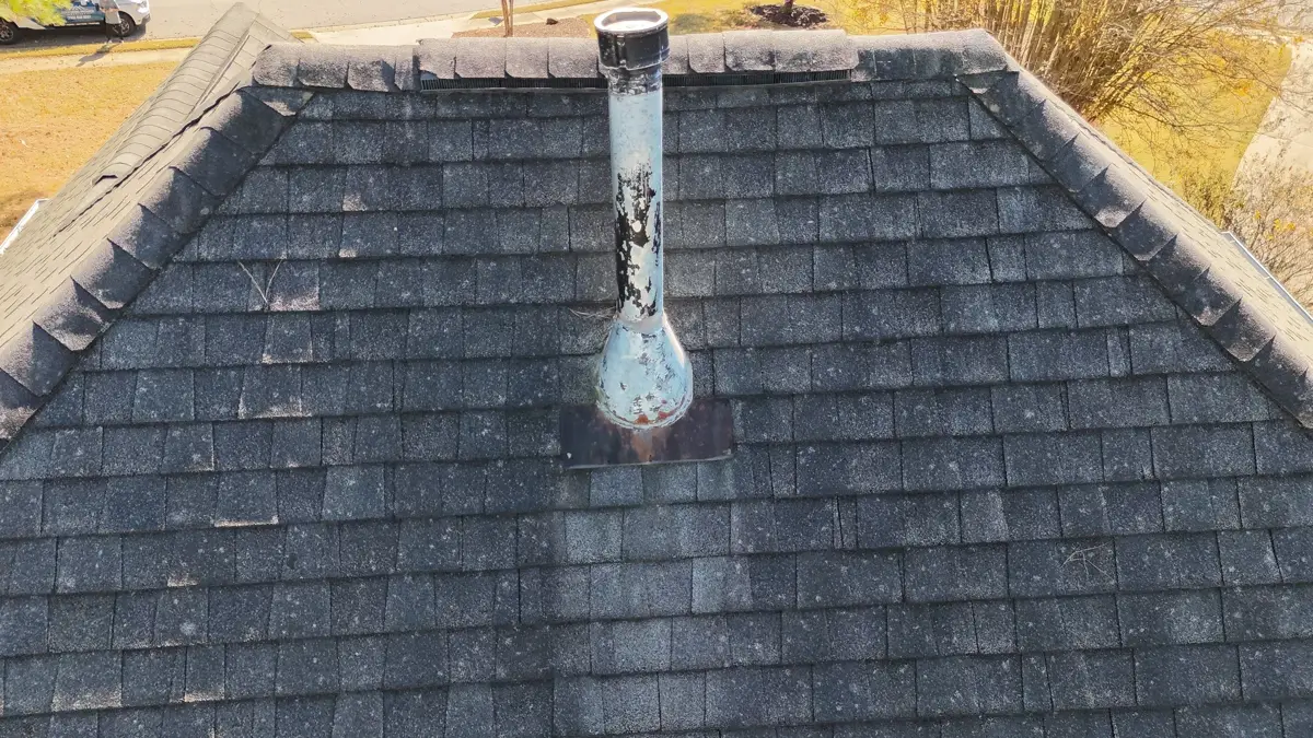 Roof shingles surrounding a weathered vent pipe flashing, Southern Premier Roofing work near Mulberry GA