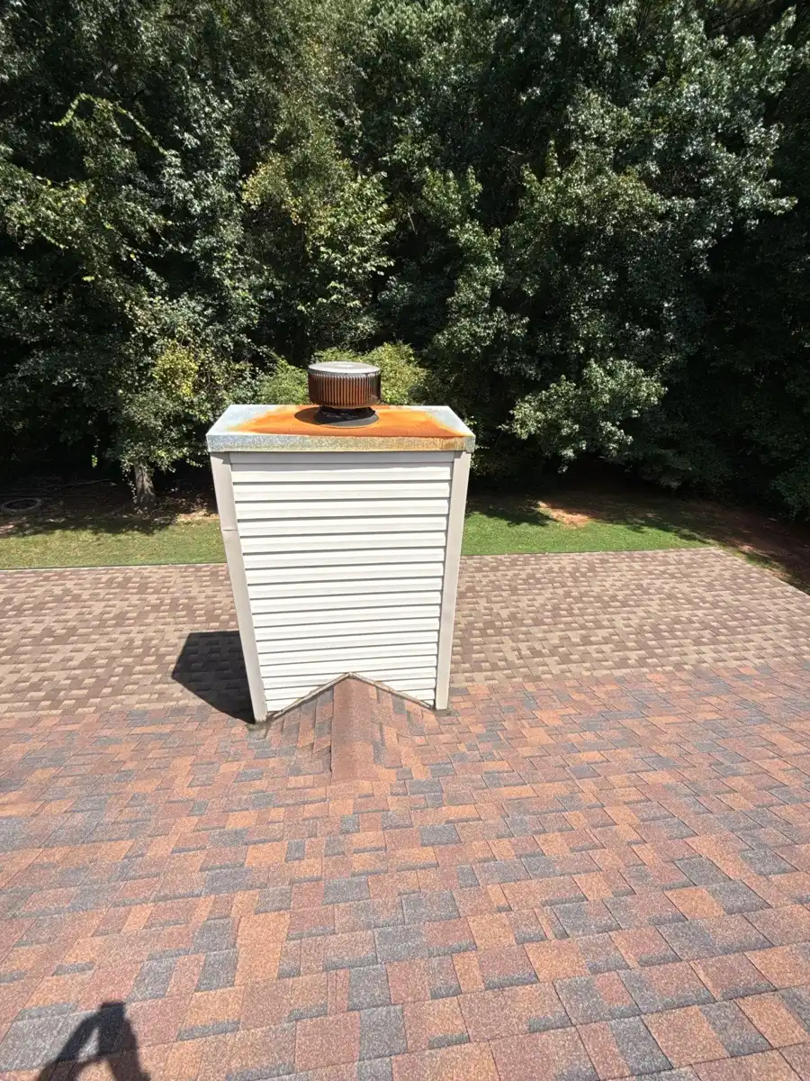 Wide view of completed shingle roof surrounding chimney, Southern Premier Roofing work near Norcross GA