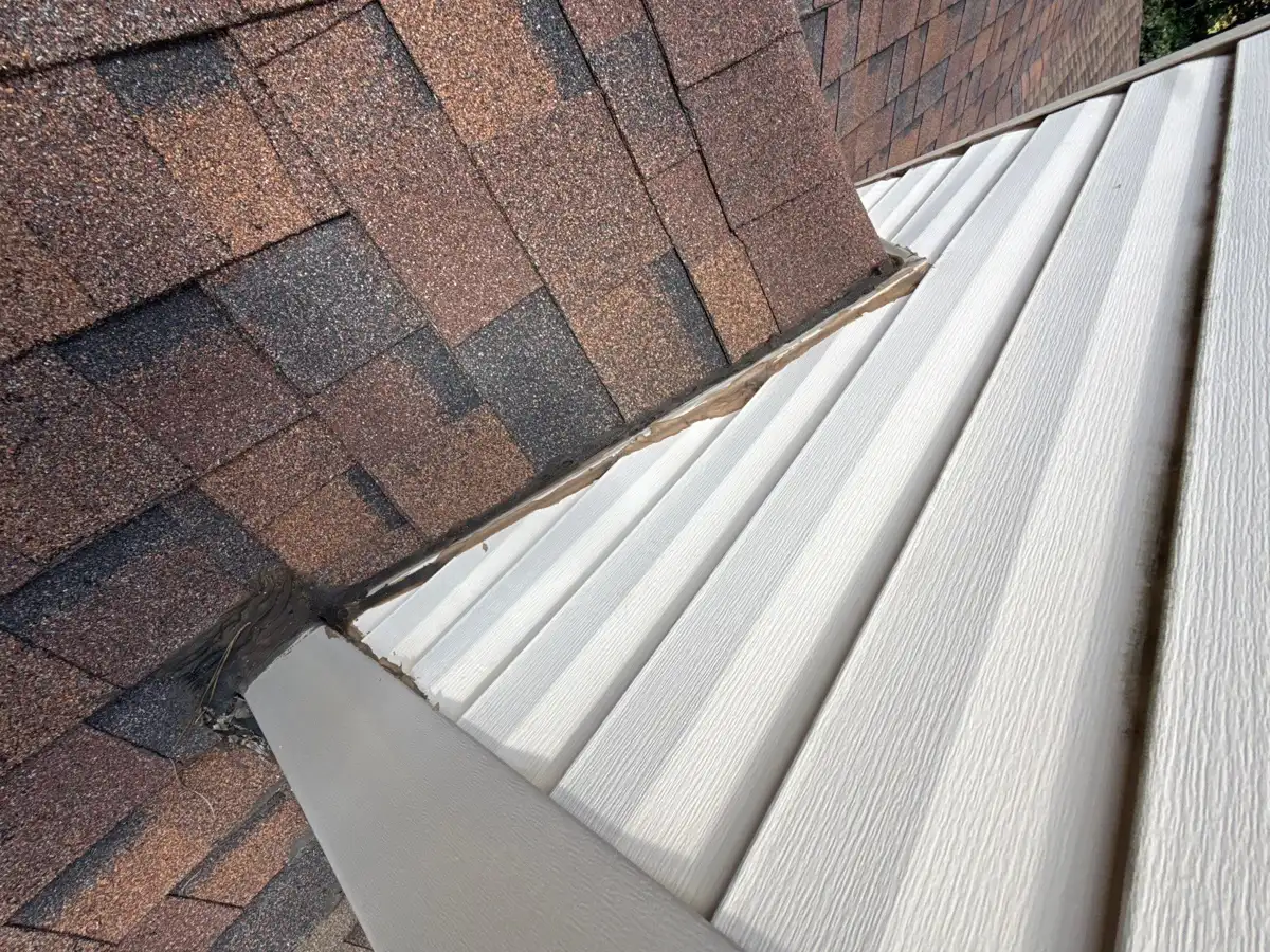 Roof shingles meet ribbed metal roofing at a narrow transition, Southern Premier Roofing work near Norcross GA