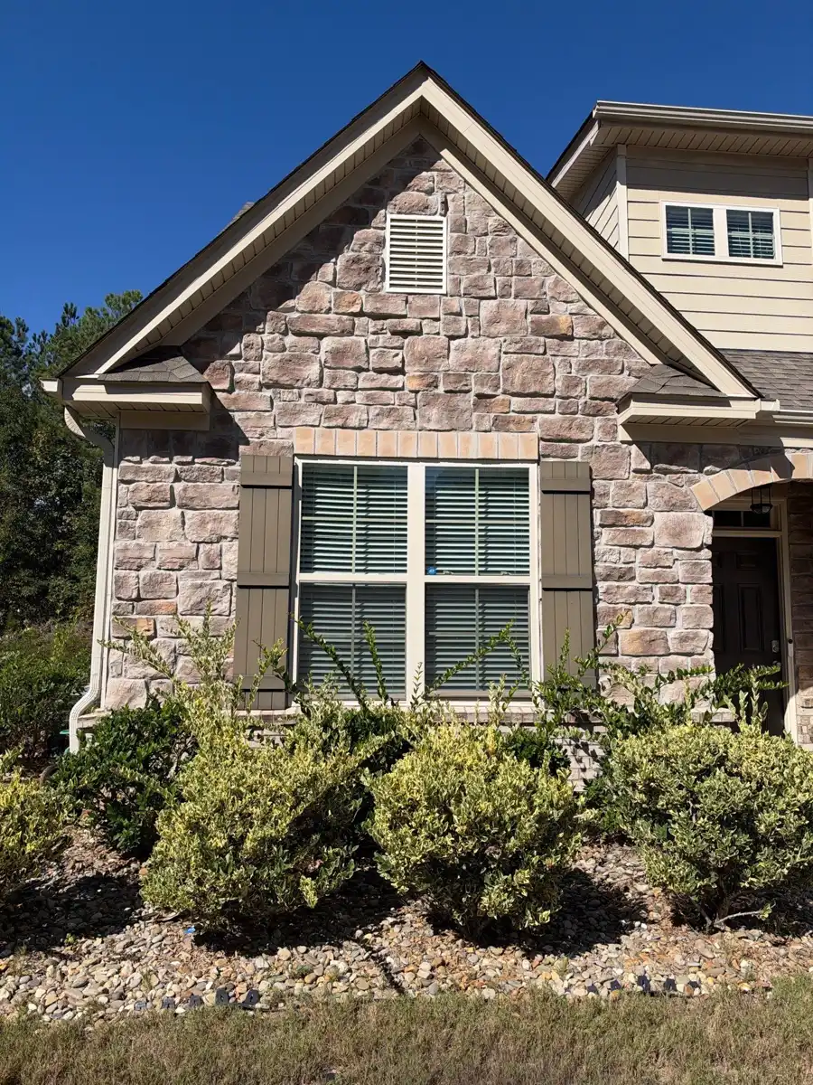 Front gable with finished shingles, stonework, and neatly trimmed shrubs, Southern Premier Roofing work near Oxford GA