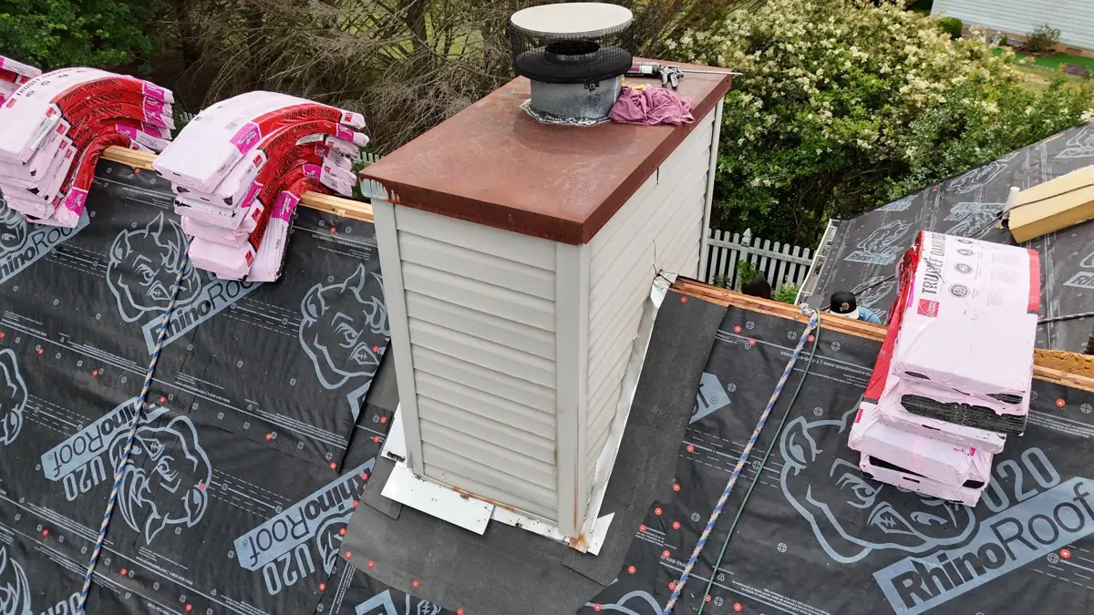 Chimney flashing surrounded by roofing underlayment and staged shingles, Southern Premier Roofing work near Pendergrass GA