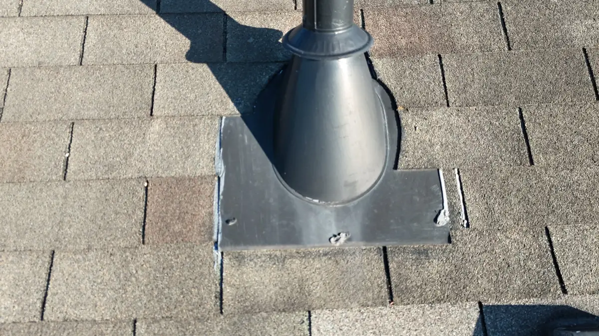 Large vent pipe secured with metal flashing on shingled roof, Southern Premier Roofing work near Snellville GA