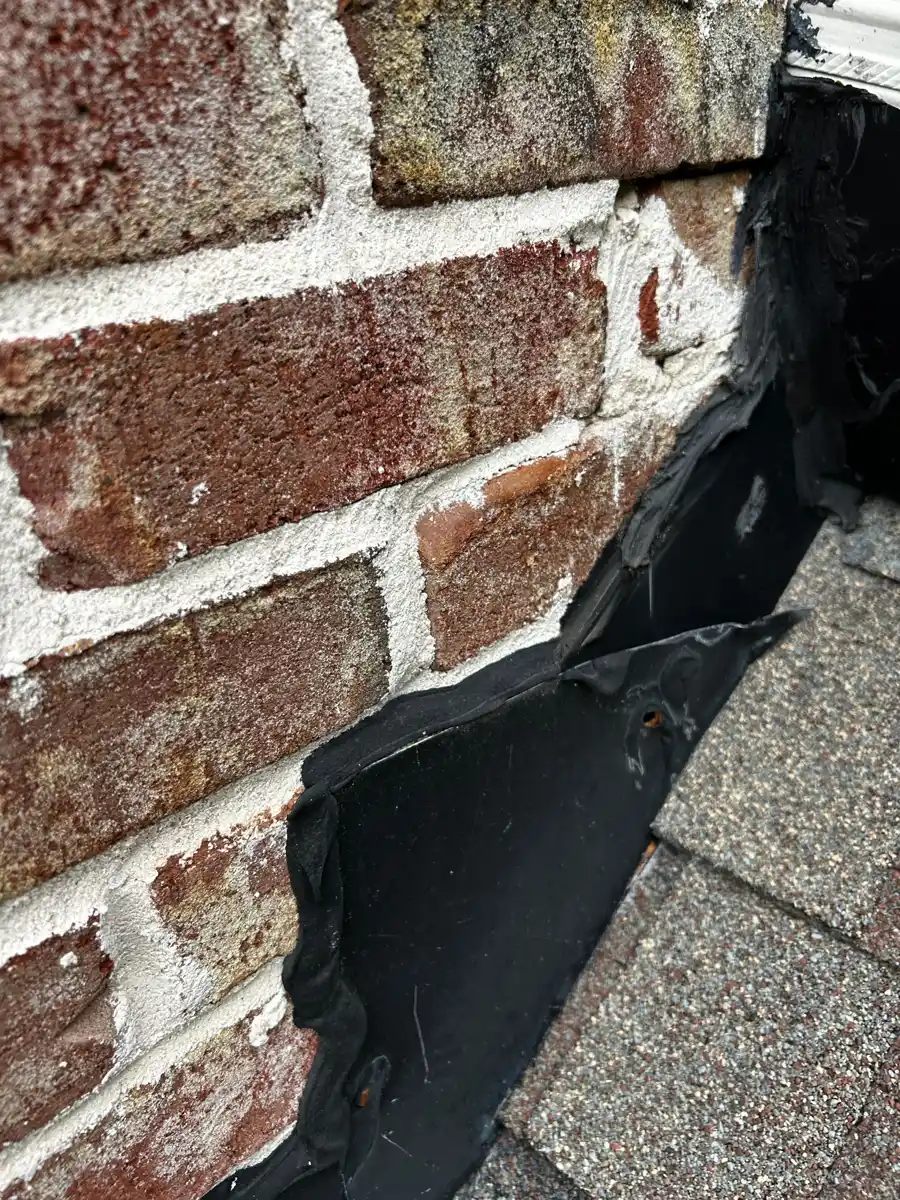 Roof-to-wall flashing detail beside brick masonry and shingles, Southern Premier Roofing work near Social Circle GA