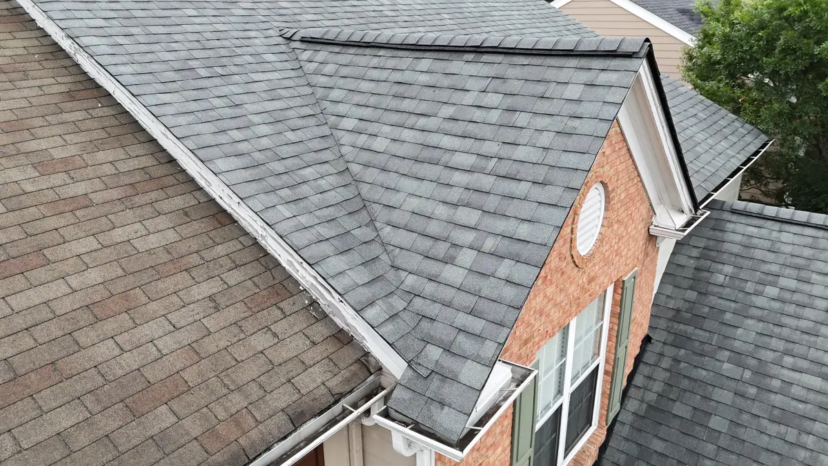 Completed roof section with gray shingles and brick gable, Southern Premier Roofing work near Stone Mountain GA