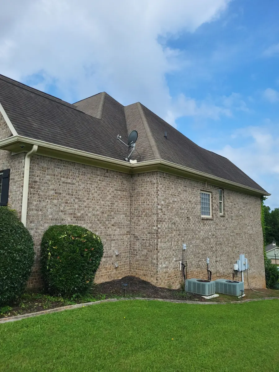 Brick home rear roof planes above lawn and exterior equipment, Southern Premier Roofing work near Tucker GA