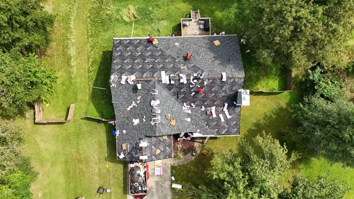Aerial view shows roof partially stripped with workers and roofing debris, Southern Premier Roofing work near Winder GA