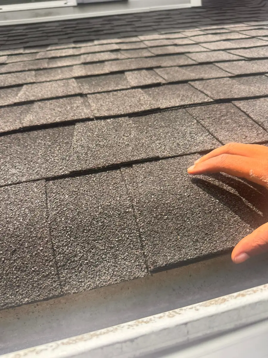Close-up of weathered asphalt shingles with lifted surface granules, Southern Premier Roofing work near Arnoldsville GA