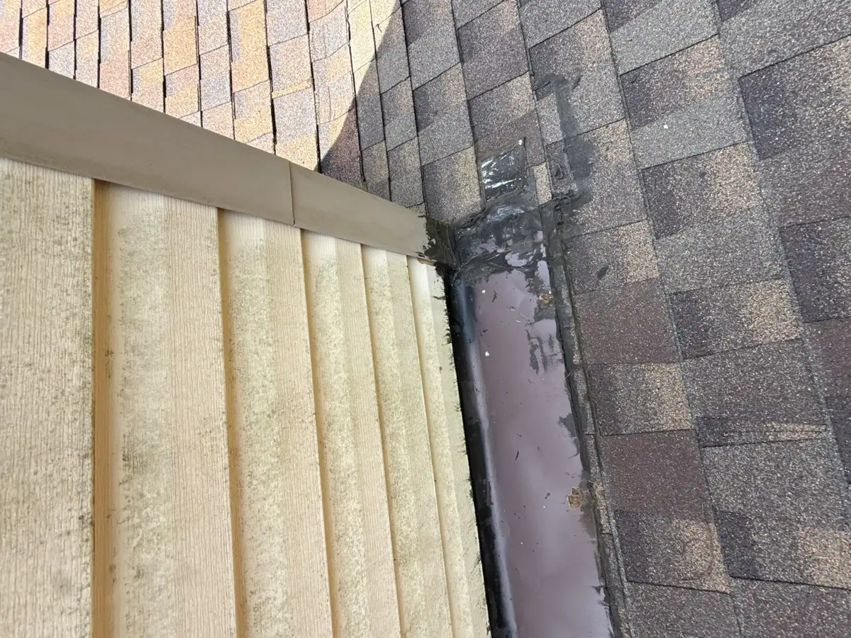Ribbed metal roof meets shingles beside a narrow flashing channel, Southern Premier Roofing work near Arnoldsville GA