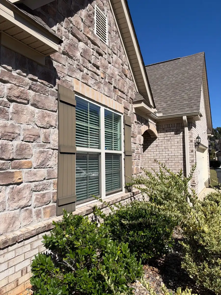 Finished roofline above stone facade and front window landscaping, Southern Premier Roofing work near Bogart GA