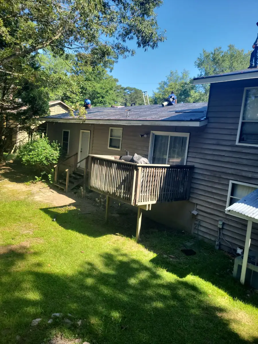 Completed shingle roof viewed above house and backyard deck, Southern Premier Roofing work near Bostwick GA