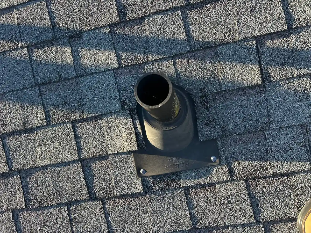 Close-up of roof shingles surrounding exposed metal vent pipe, Southern Premier Roofing work near Commerce GA