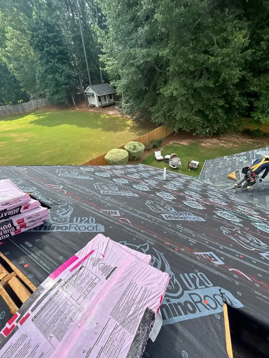 Roof underlayment and pink shingle bundles overlooking wooded backyard, Southern Premier Roofing work near Conyers GA
