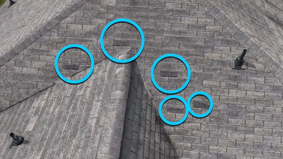 Roof ridge with several circled areas marking shingle concerns, Southern Premier Roofing work near Covington GA