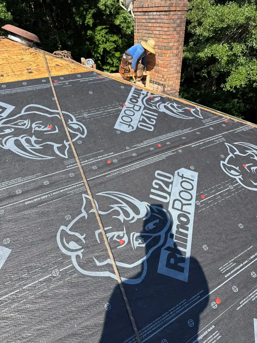 Printed roofing underlayment covers deck beside brick chimney, Southern Premier Roofing work near Cumming GA