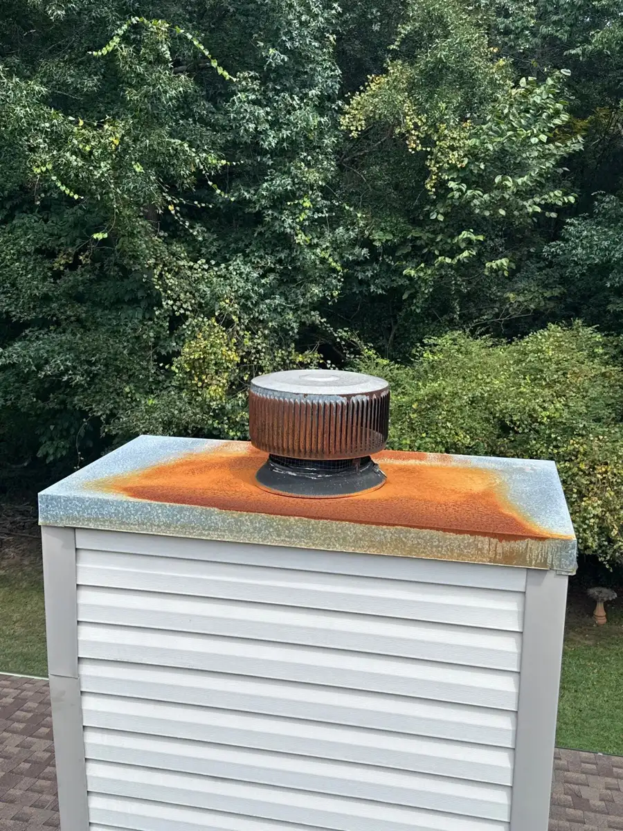 Close view of chimney cap and heavily rusted surrounding flashing, Southern Premier Roofing work near Duluth GA