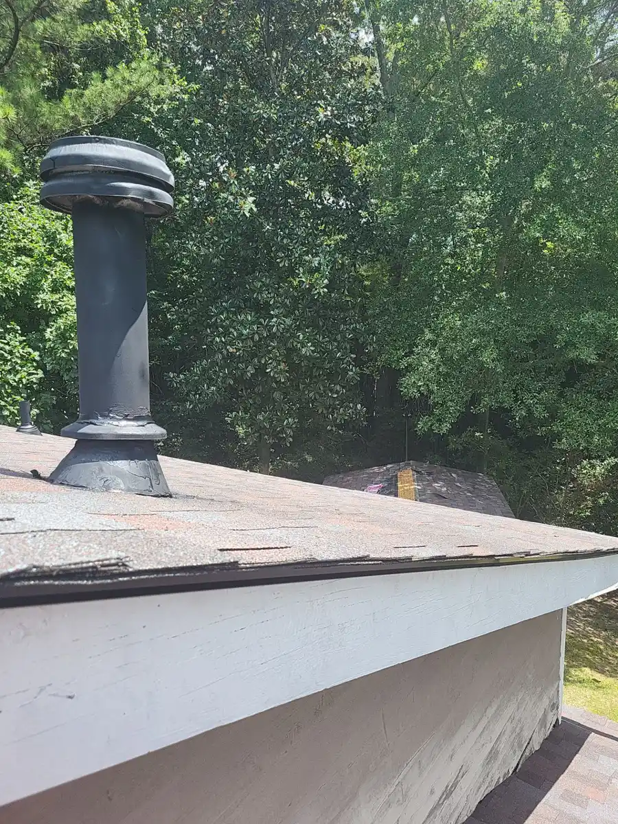 Roof edge flashing and vent pipe visible above white wall, Southern Premier Roofing work near Hoschton GA