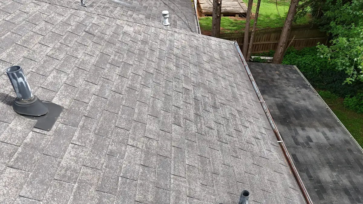 Weathered shingle roof with vent pipes and adjacent lower roof, Southern Premier Roofing work near Hoschton GA