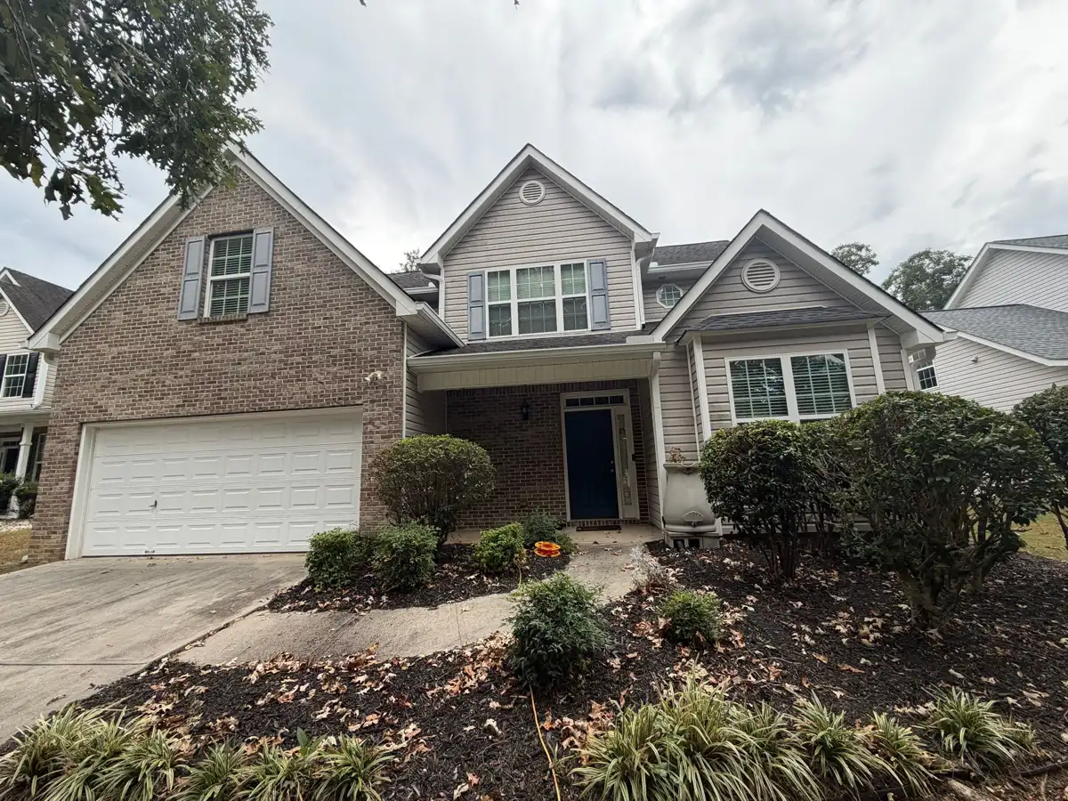 Front exterior showing completed roof, brick facade, garage, and landscaping, Southern Premier Roofing work near Ila GA