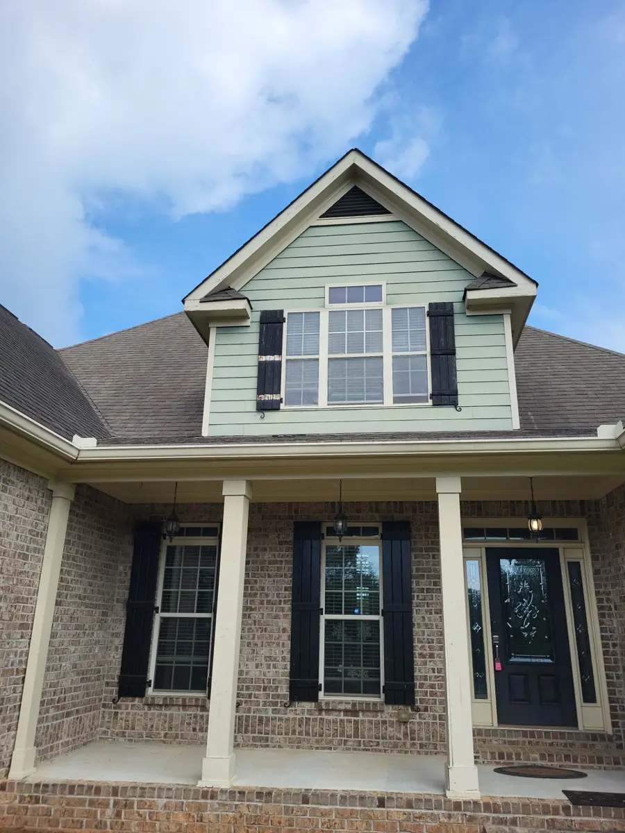 Front gable and roofline above brick porch with columns, Southern Premier Roofing work near Johns Creek GA